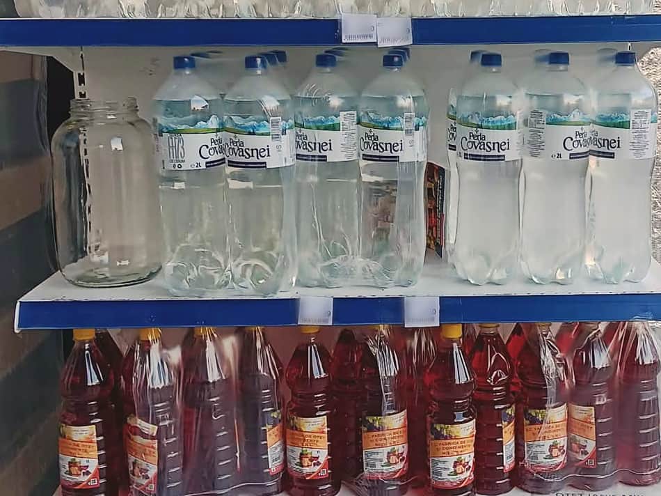 Raft cu sticle de apă plată de 2 litri și, dedesubt, sticle de oțet de vin